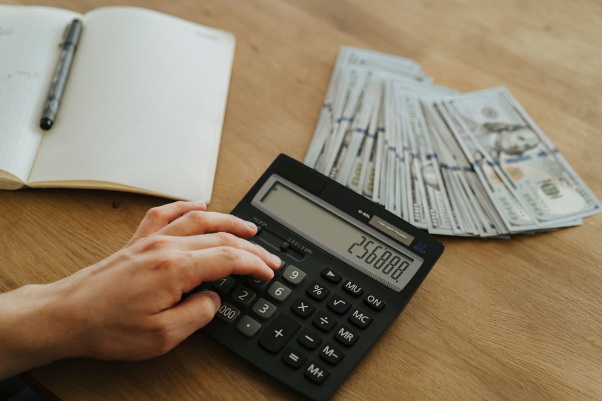 mão fazendo contas na calculadora para calcular o valor líquido das vendas
