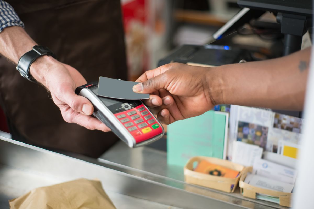 cliente pagando com cartão na maquininha de uma loja